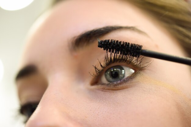 Woman applying makeup eyelashes