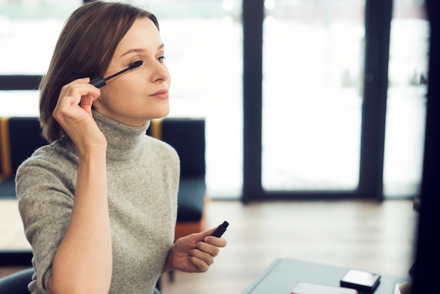 Donna che applica il mascara