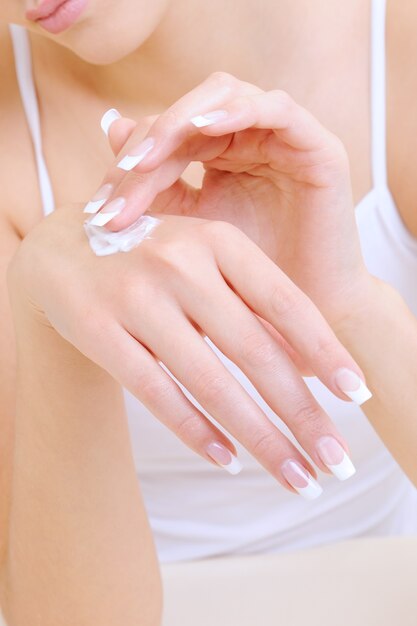 Woman applying the moisturizing cosmetic cream on hands
