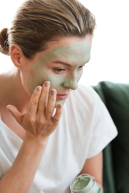 Free photo woman applying organic facial mask