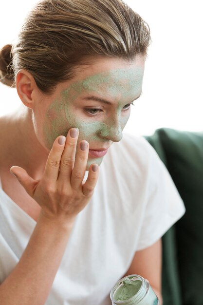 Woman applying organic facial mask