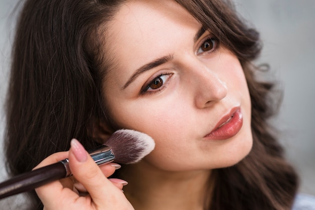 Woman applying powder on face