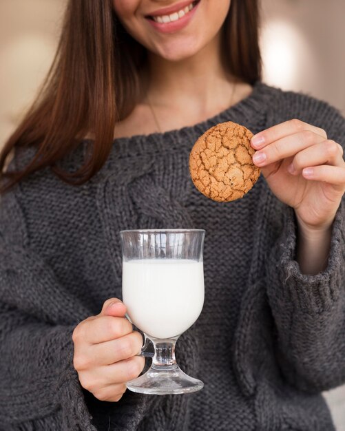 クッキーと牛乳と肘掛け椅子の女性