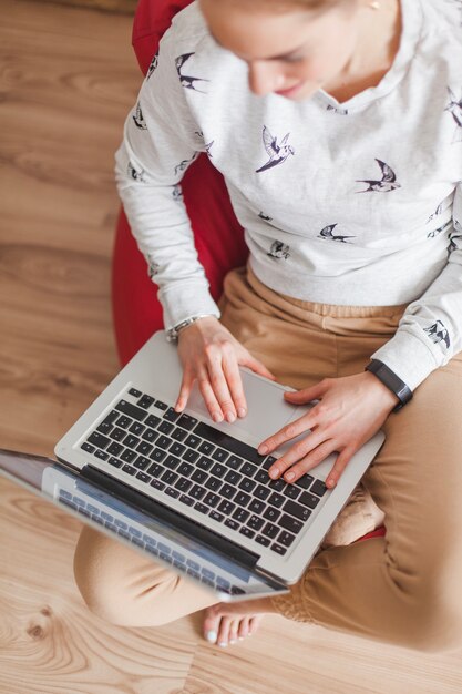 Woman on armchair with laptop top view