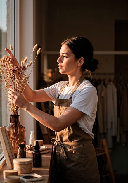 woman arranging dried flowers