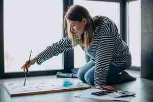 Foto gratuita artista della donna che dipinge un'immagine a casa