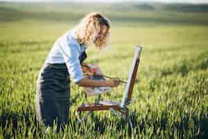 Foto gratuita pittura dell'artista della donna con le pitture ad olio in un campo