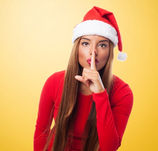 Woman asking for silence in a yellow background