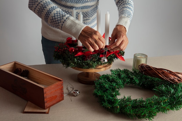 Free photo woman assembling holiday themed wreath