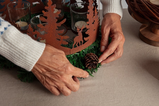 Free photo woman assembling holiday themed wreath