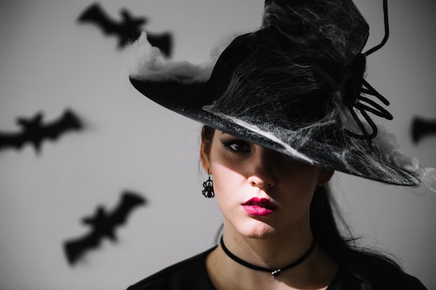 Бесплатное фото Женщина в летучих мышах в шляпе хэллоуина