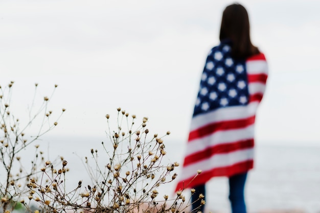 Бесплатное фото Женщина в море, покрытая американским флагом