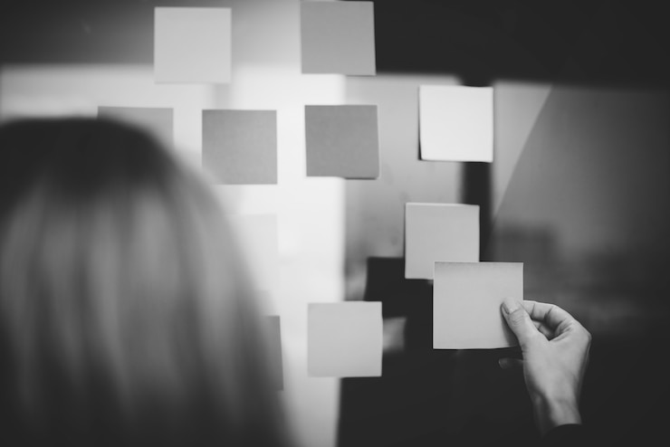 Free Photo woman attaching a note to a board
