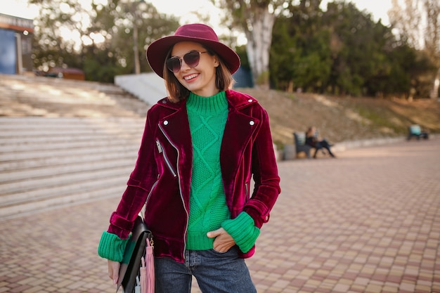 woman in autumn style trendy outfit walking in street wearing purple velvet jacket, sunglasses and hat