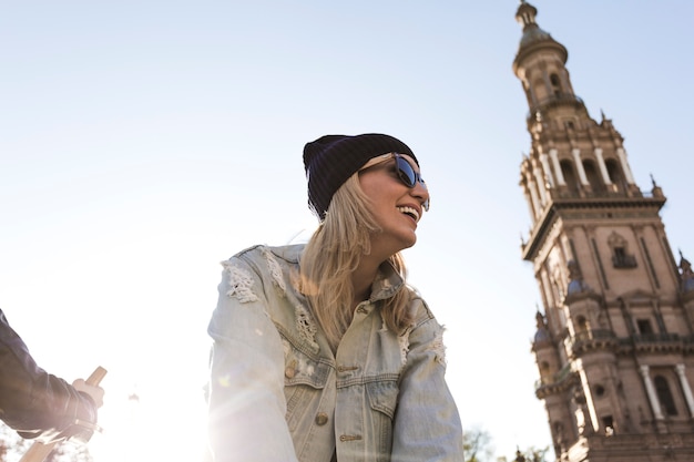 Foto gratuita donna sullo sfondo del cielo e la torre