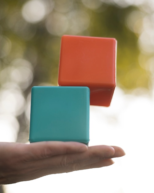 Woman balancing colored plastic cubes