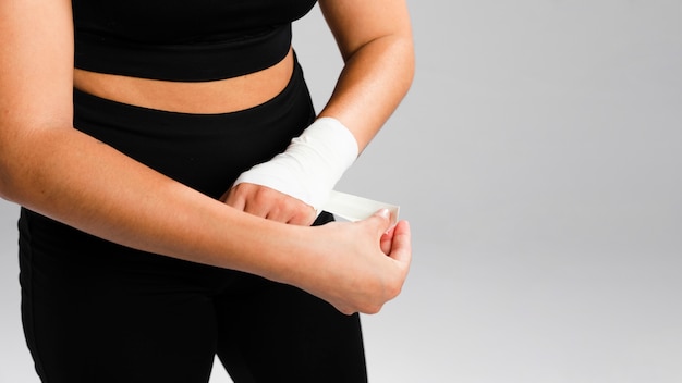 Woman bandaging her hands high view