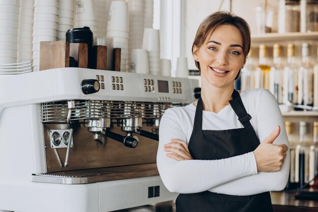 Woman barista at a coffee shop preparing coffee