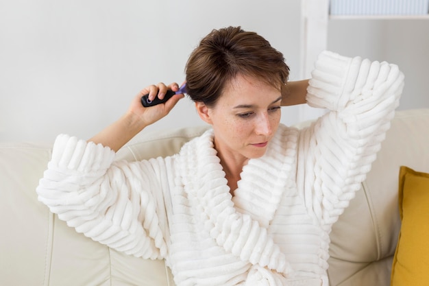 Foto gratuita donna in accappatoio spazzolarsi i capelli