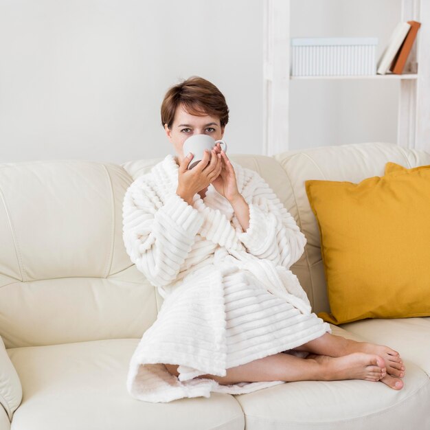 Woman in bathrobe drinking tea