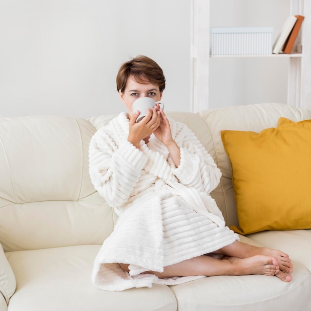 お茶を飲むバスローブの女性