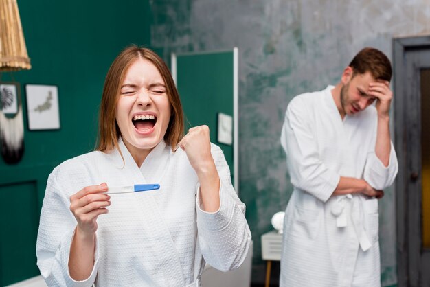 Woman in bathrobe excited about pregnancy test