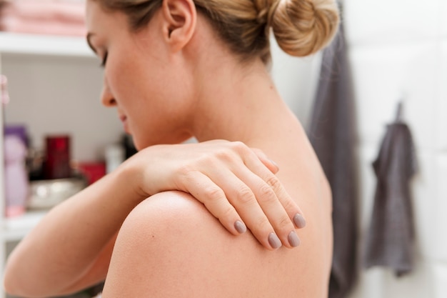 Woman in the bathroom with hand on her back