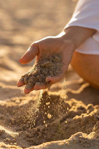그녀의 손에 모래를 들고 해변에서 여자