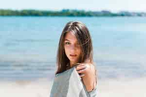 Free photo woman in beach scarf looking at camera