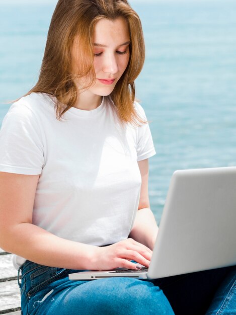 Woman at the beach working on laptop