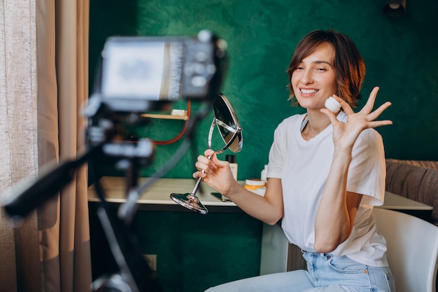 Woman beauty vlogger filming vlog about creams