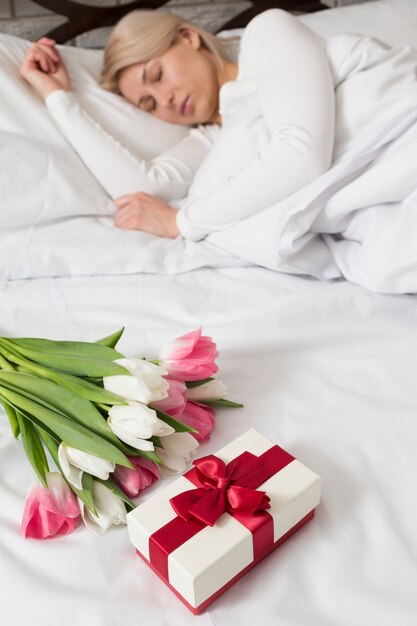 꽃과 선물에 놀란 침대에서 여자