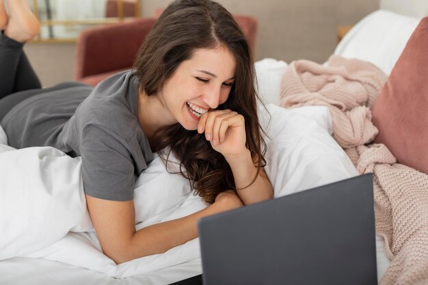 Woman in bed using laptop