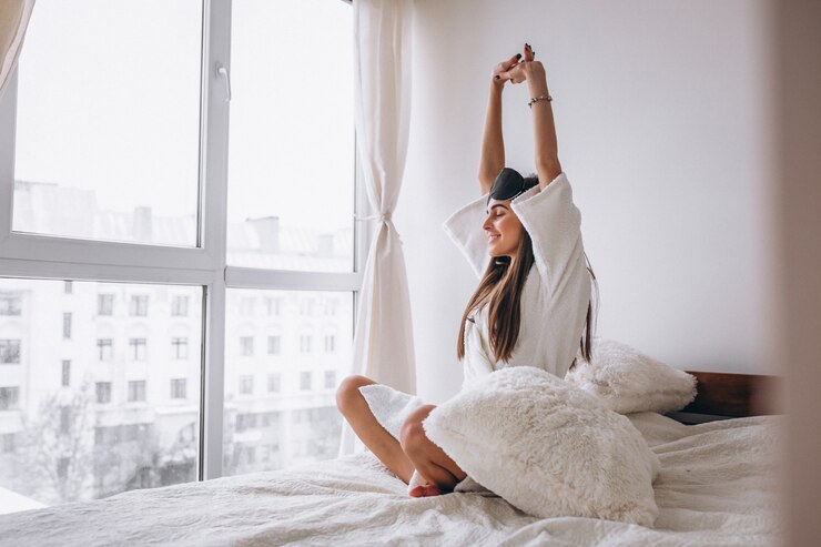 Free Photo woman in bed wearing sleeping mask