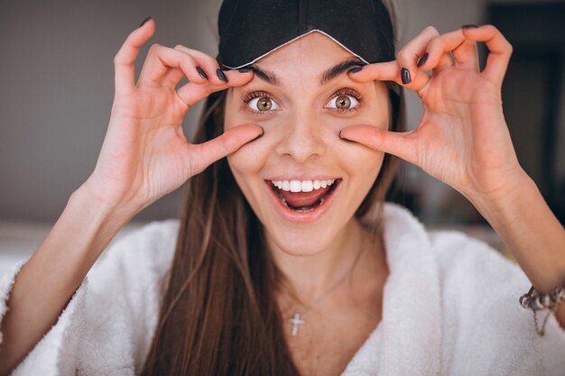 Woman in bed wearing sleeping mask