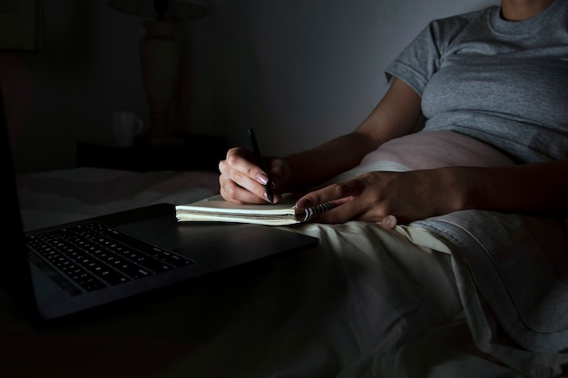 Free photo woman in bed working late