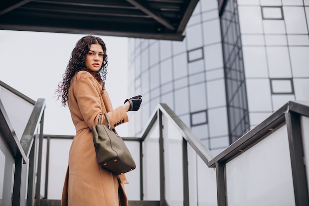 Woman in beige coat walking in the city