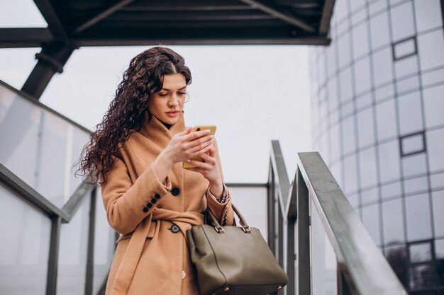 Woman in beige coat walking in the city