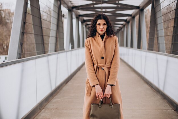 Free photo woman in beige coat walking in the city