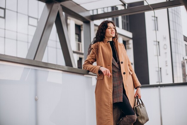 Woman in beige coat walking in the city