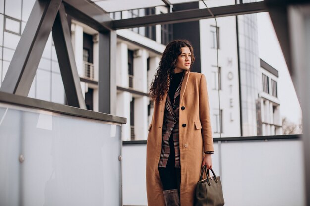 Woman in beige coat walking in the city