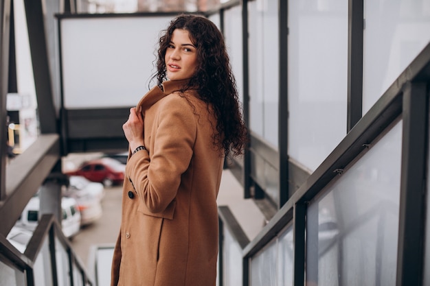 Woman in beige coat walking in the city