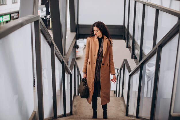 Woman in beige coat walking in the city