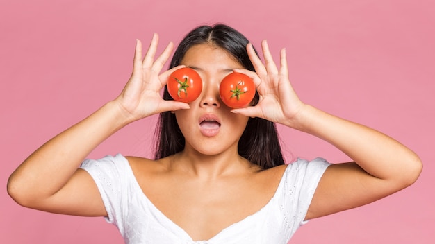 Woman being surprised and holding tomatoes