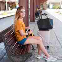 Foto gratuita donna sulla panchina nella stazione ferroviaria