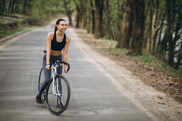 Donna in bicicletta nella foresta