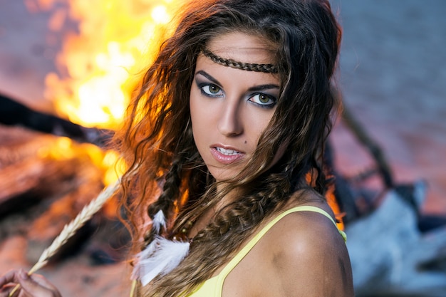 Free photo woman in bikini posing near a bonfire