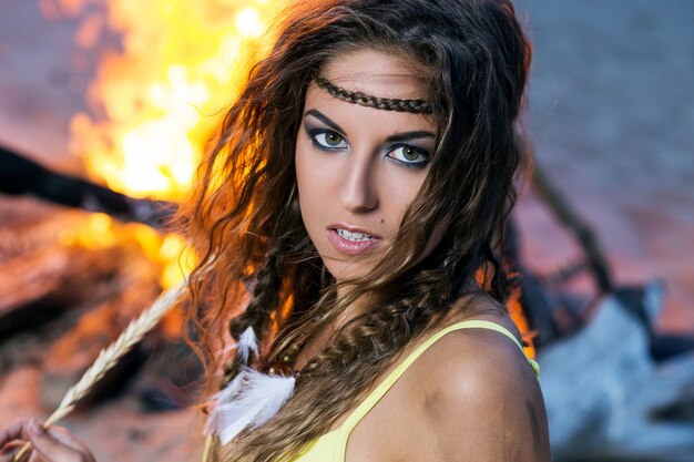 Woman in bikini posing near a bonfire