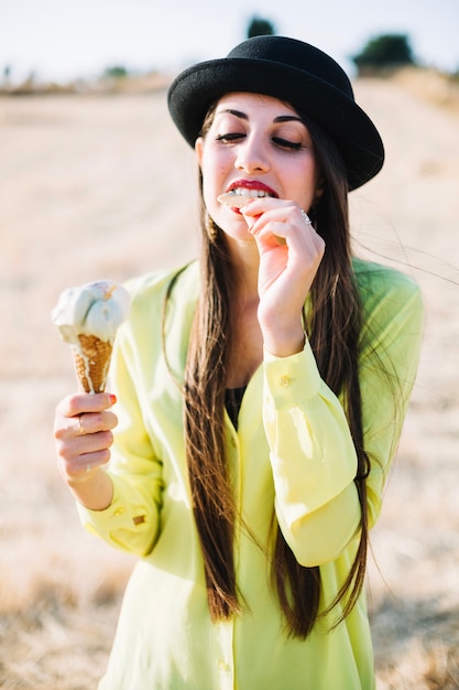 Free photo woman biting waffle of ice cream