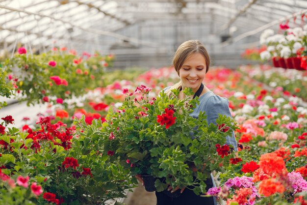 Woman in a black apron working in a greenhouse